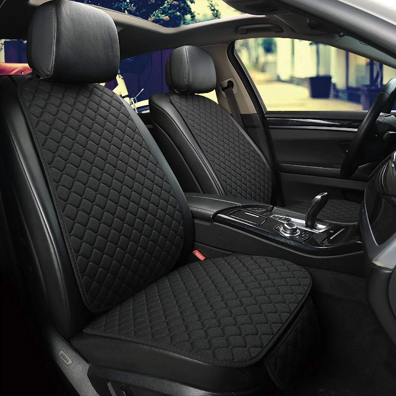 Car interior with black quilted seat covers on the front seats.