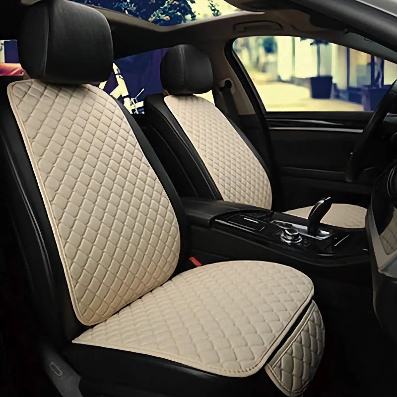 Car interior with beige quilted seat covers on the front seats.